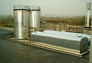 Bitumen storage tank with horizontal parallelepiped and vertical cylindrical section, complete with automatic valves and electrical level indicator.